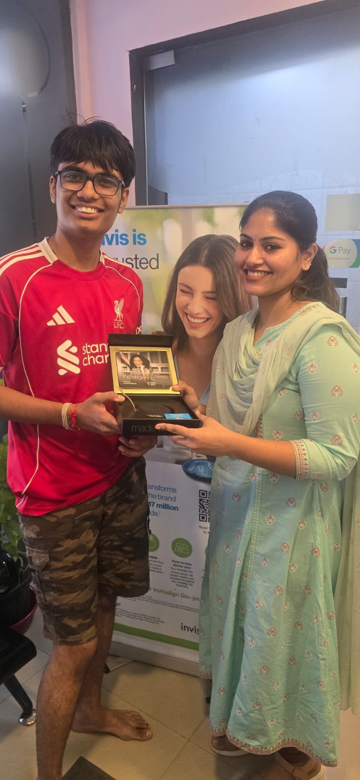 Visitor and team member holding an Invisalign presentation box at Glodent Dental Care, Perungudi